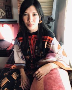 Woman sitting on colorful sofa looking at camera